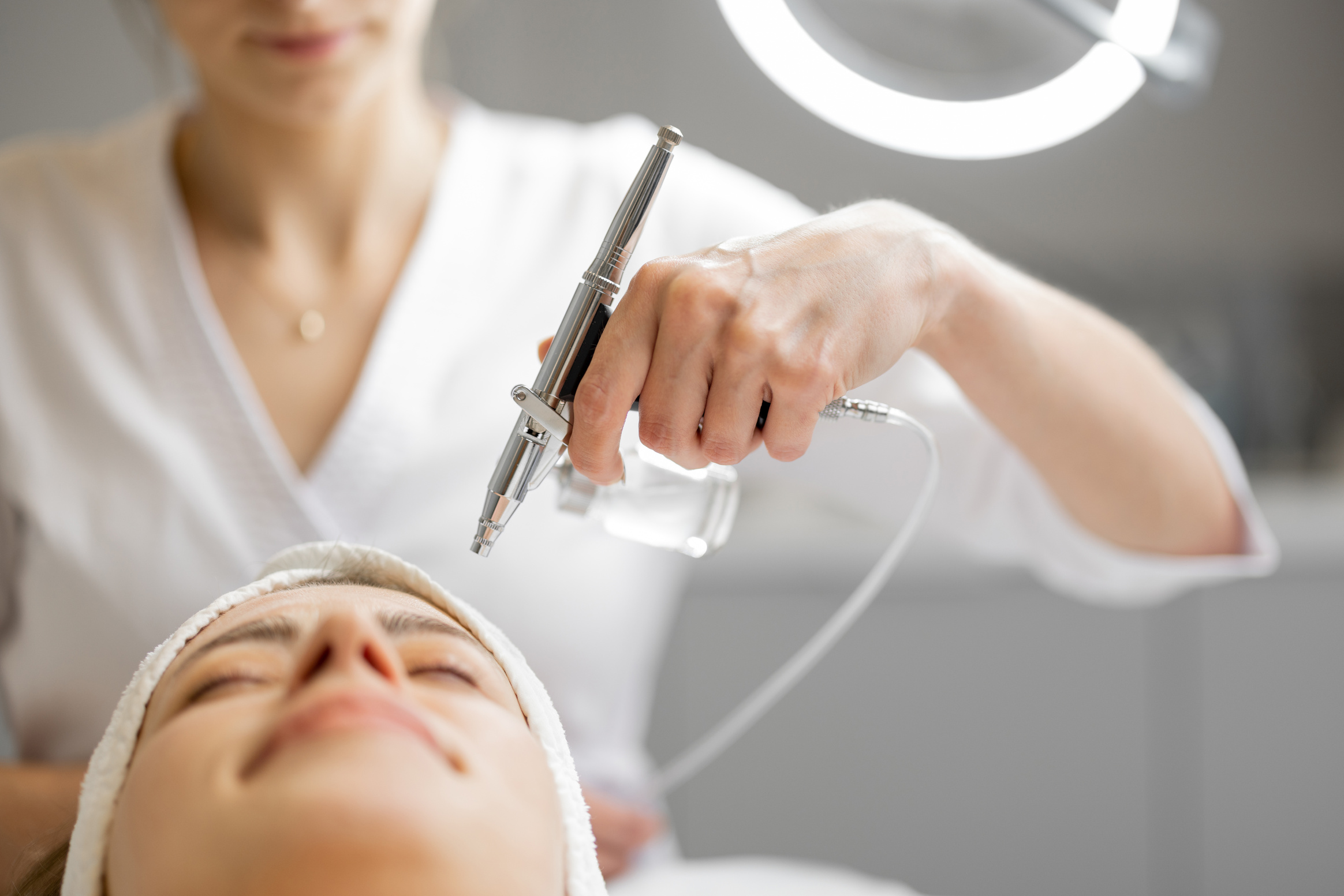 Cosmetologist Performing Oxygen Mesotherapy on Woman's Face